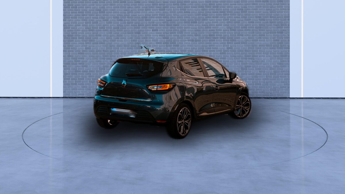 The same teal hatchback on a plain studio backdrop, lit evenly and reflected on the floor beneath it
